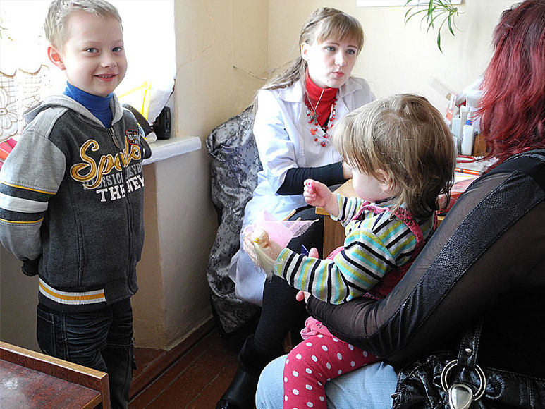 Mutter mit ihren Kindern bei einer Ärztin