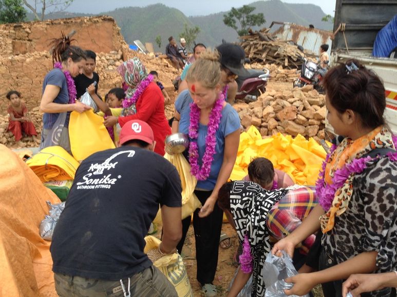 Bewohner empfangen Helfer mit Blumenkränzen