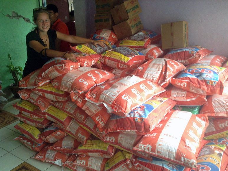 Germaid Ponge vor einem Stapel Reissäcken