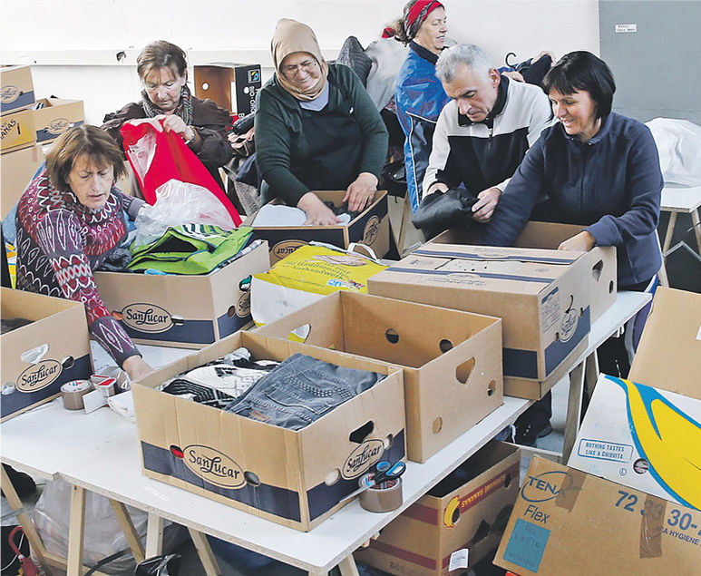 Helfer beim Sortieren der Kleider in Kartons